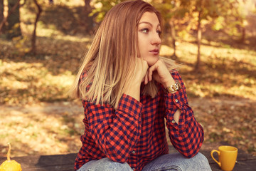 Portrait of beautiful woman enjoying and posing in autumn day.