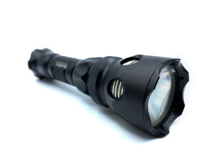 Close-up of a black modern flashlight, isolated on white background