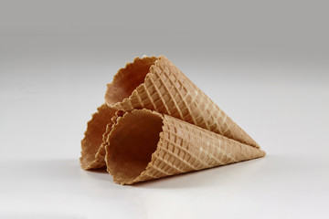 Three empty, crispy wafer cones for ice cream isolated on white. Concept of food, treats. Mockup, template for your advertising and design. Close up
