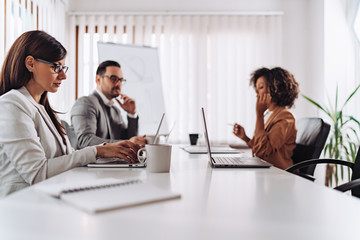 Business team at the meeting using laptop and discussing