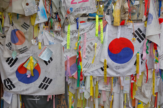 Barbed wire fence separates South from North Korea - South Korean flags and prayer wishes attached to fence for those separated or who had died during the Korean War - NOVEMBER 2013