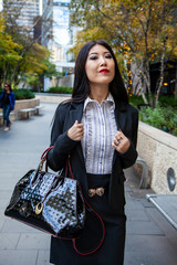 Beautiful Chinese Asian woman in fashionable business attire is enjoying a nice day walking around...
