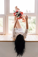 brunette bride lying enjoying her bright bouquet in live coral color
