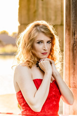 A woman in a red dress stands on a background of a medieval castle