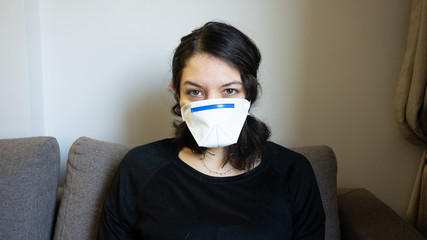 Woman at home during Corona times home office with mask in quarantine