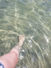 Obraz premium perna feminina em água cristalina, férias, praia, mar, nordeste