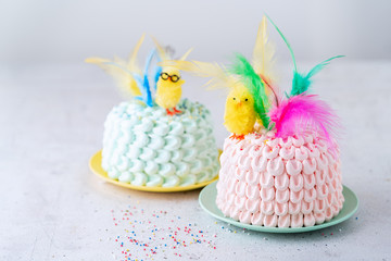 Easter cake decorated with little yellow easter chick and colorful feathers. Mona de Pascua. Spanish cuisine. Copyy space.
