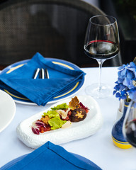 Italian cuisine dish tomatoes carpaccio with vegetables and cheese on the white servet table,...