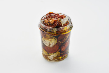 dried tomatoes in olive oil with herbs on a white background
