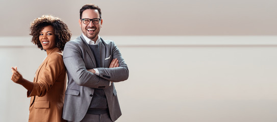 Portrait of cheerful multi ethnic business couple looking at camera