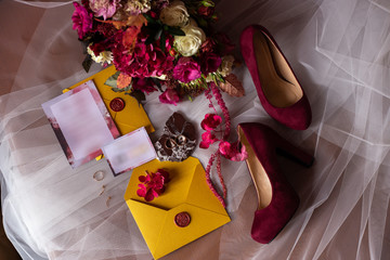 wedding accessories: a bride’s bouquet of roses, peonies and hydrangeas, wedding rings on a...
