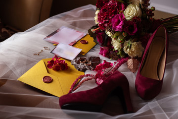 wedding accessories: a bride’s bouquet of roses, peonies and hydrangeas, wedding rings on a...