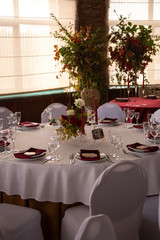 banquet round tables decorated with a bouquet in the center of the tables