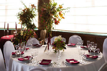 banquet round tables decorated with a bouquet in the center of the tables