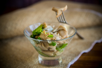 pickled mushroom salad with lettuce, onions and herbs in a glass bowl