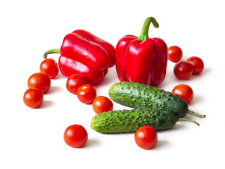 Fresh red bell peppers, green cucumbers, cherry tomatoes on a white background