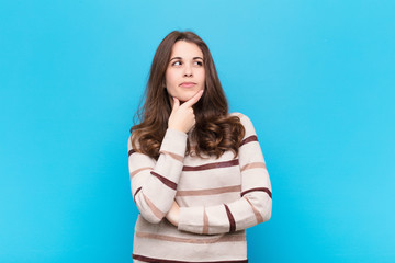 young pretty woman thinking, feeling doubtful and confused, with different options, wondering which...