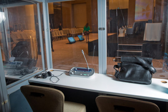 Soft focus of wireless Conference microphones and notebook in a meeting room. translators cubicle . interpreting - Microphone and switchboard in an simultaneous interpreter booth .