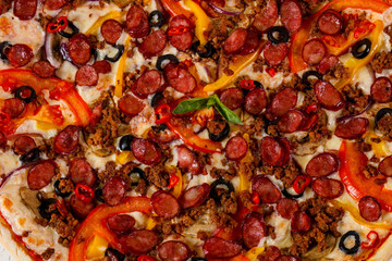 Pizza with sausages and minced meat
