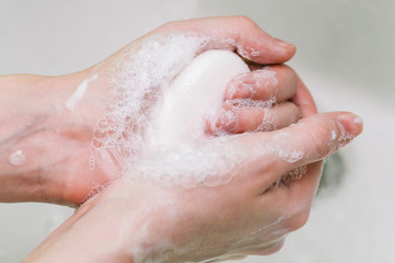 Woman uses soap and washes her hands under a faucet. Hygiene and hand cleaning. Prevention and control of coronavirus.