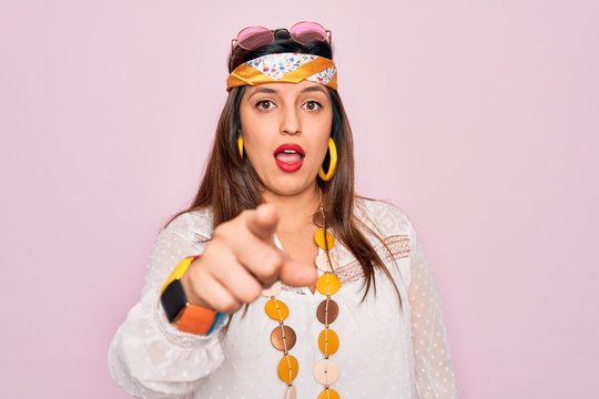 Young hispanic hippie woman wearing fashion boho style and sunglasses over pink background pointing displeased and frustrated to the camera, angry and furious with you