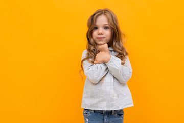 Fototapeta premium Portrait of little caucasian girl is embrassed isolated on yellow background