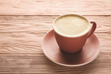Cup of tasty cappuccino on wooden background