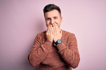 Young handsome caucasian man wearing casual winter sweater over pink isolated background laughing...
