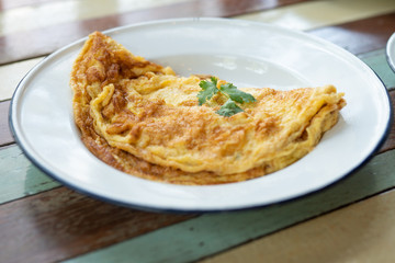 Thai style omlette classic in zinc metal plate that coating with white color on vintage table
