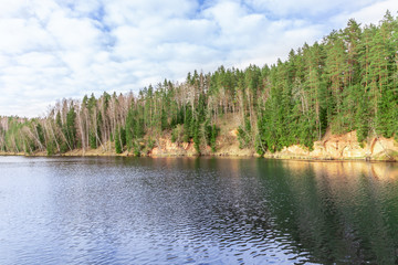 Beautiful lake in the forest with blue sky and clouds