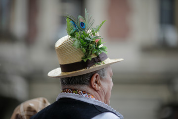 Details with the traditional Romanian straw hat of a senior man, adorned with flowers, leaves and peacock feathers.