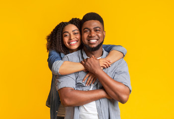 Obraz premium Portrait of black couple in love hugging and smiling at camera