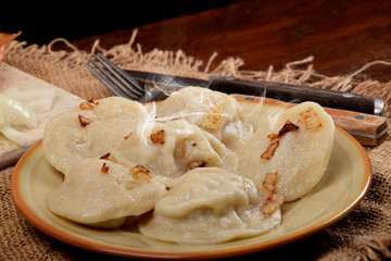 dumplings stuffed with meat, topped with fat and fried onions