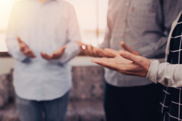 Three of people standing while raising up hands in prayer and worship God together