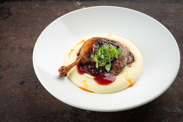 Cooked Duck legs with mashed potatoes with lingonberry sauce and herbs