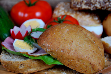 sandwich with lettuce, ham and boiled egg rings, cucumbers and dill