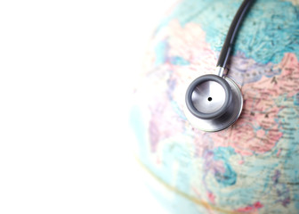Close up of stethoscope  on top of the blurred of a world globe  with copy space, Pandemic concept 
