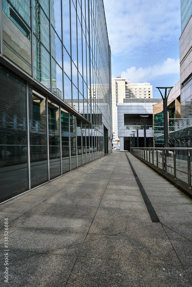 Poster Promenade between modern buildings with glass walls in Poznan