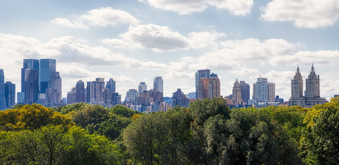 View of the Manhattan West Side with Central Park treetops in the front.