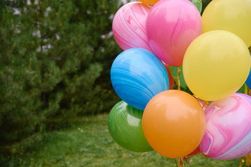 Fototapeta na wymiar Bunch of yellow, pink, blue, orange and green balloons outdoors, copy space. Holiday party decoration. Colorful balloons. Valentines day