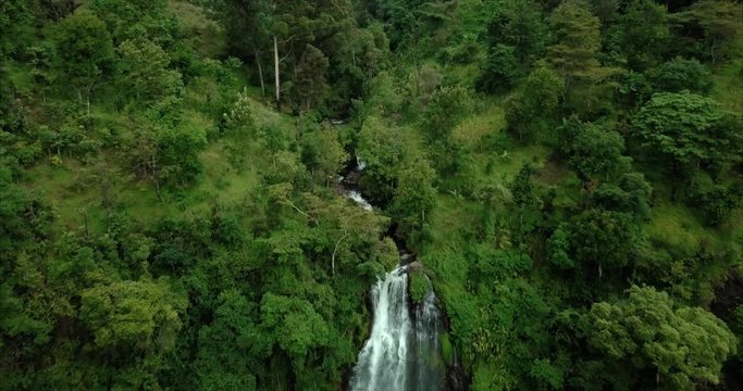 Big waterfall surrounded by green hills and jungle, aerial shot at Materuni village, Kilimanjaro Mountain, Tanzania
