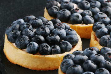 Blueberry tart on the table. Closeup of two tartlets with fresh blueberries