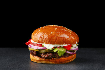 tasty burger with beef on dark isolated background. Homemade hamburger or burger with fresh vegetables and cheese