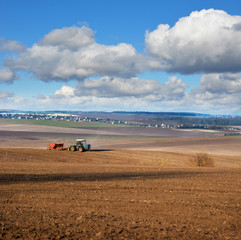 Fototapeta na wymiar Wonderful panoramic view of land, tractor with seeder, sowing time in spring
