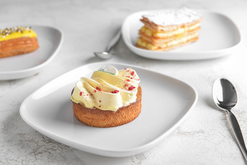 Plate with tasty cake on white table
