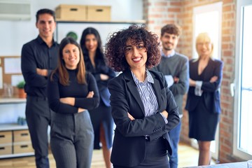 Obraz premium Group of business workers smiling happy and confident. Posing together with smile on face looking at the camera, young beautiful woman with crossed arms at the office