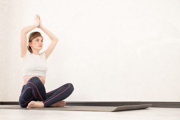 Young sporty woman practicing yoga lesson sitting in Sukhasana exercise, Easy Seat pose with mudra...