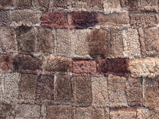 Brown background of rectangles of various sizes and shades, fur texture, close-up. Abstract, creative background in dark colors.