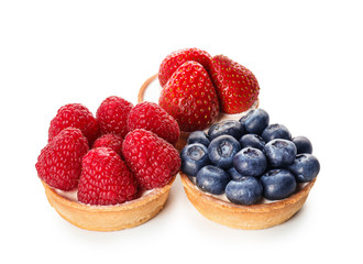 Tasty cakes with berries on white background