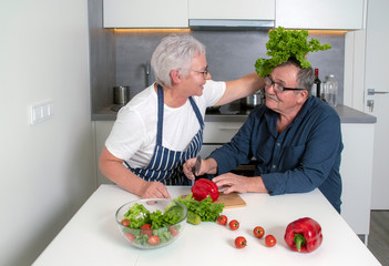 Senior couple preparing salad together. Healthy food during coronavirus quarantine. Concept of healthy nutrition in older age